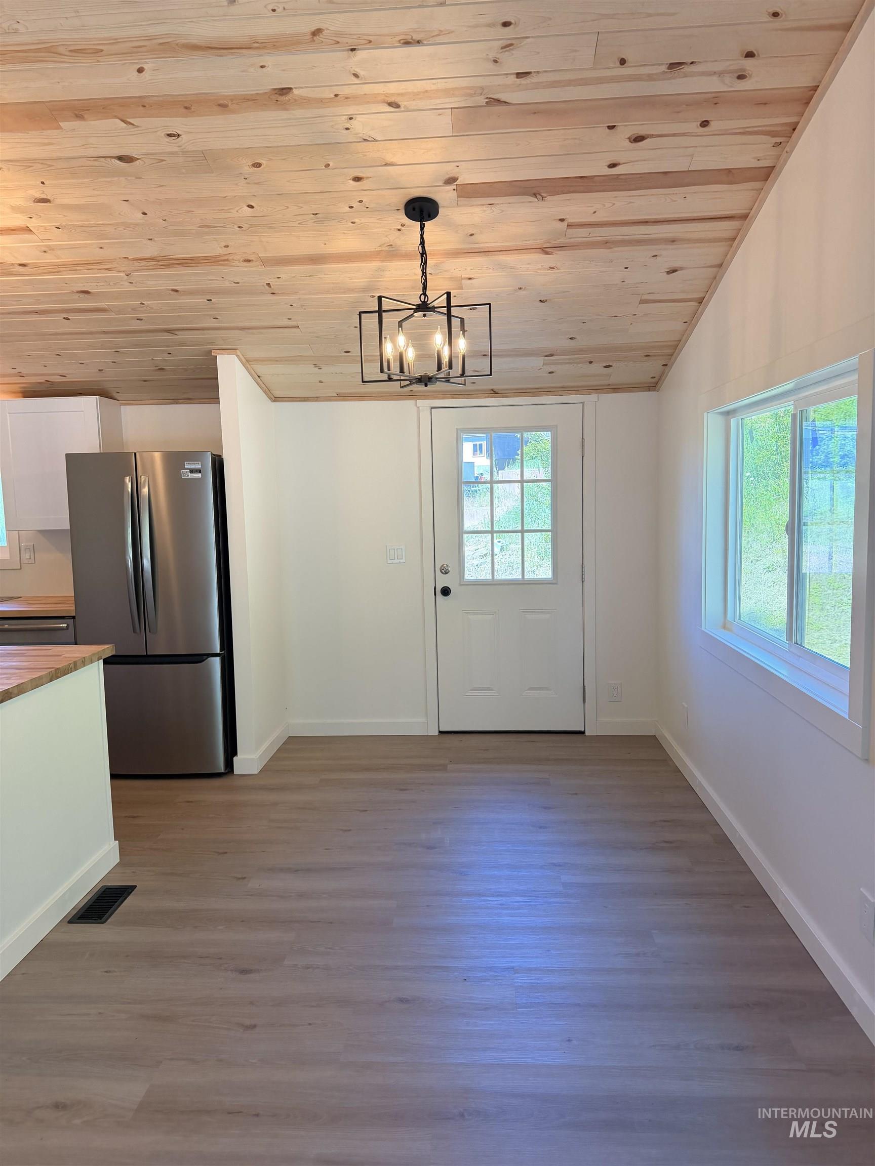 151 View Road Kamiah, ID 83536 - Photo 29 of 49 Open-concept dining area featuring wood-finish flooring, a wood plank ceiling, and a modern geometric light fixture