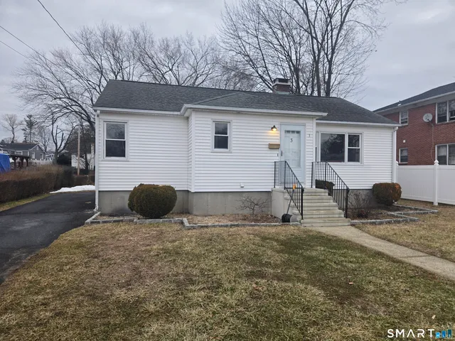 a kitchen with stainless steel appliances granite countertop a sink a stove a refrigerator cabinets and a window