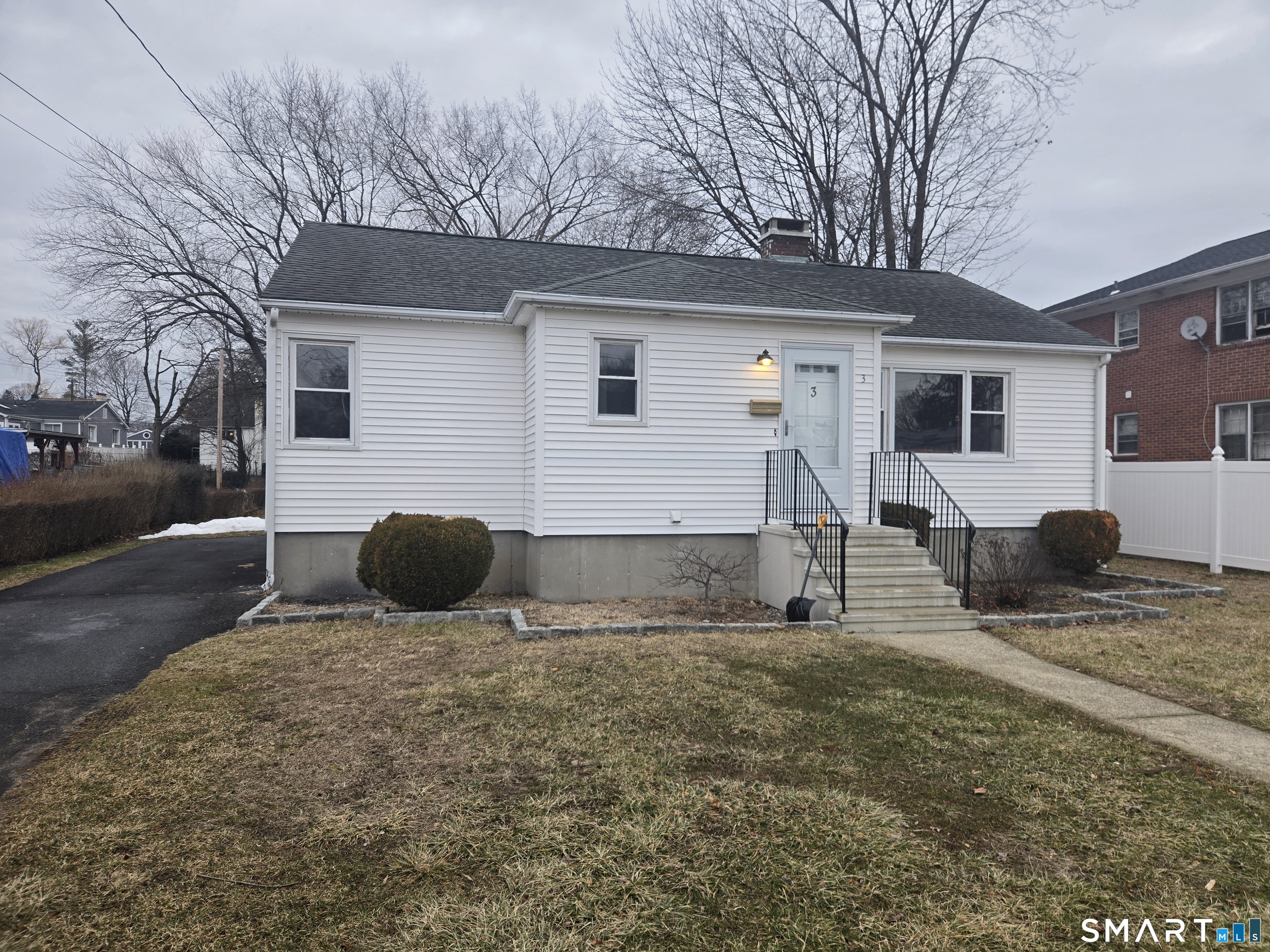 a view of house with backyard and trees in the background