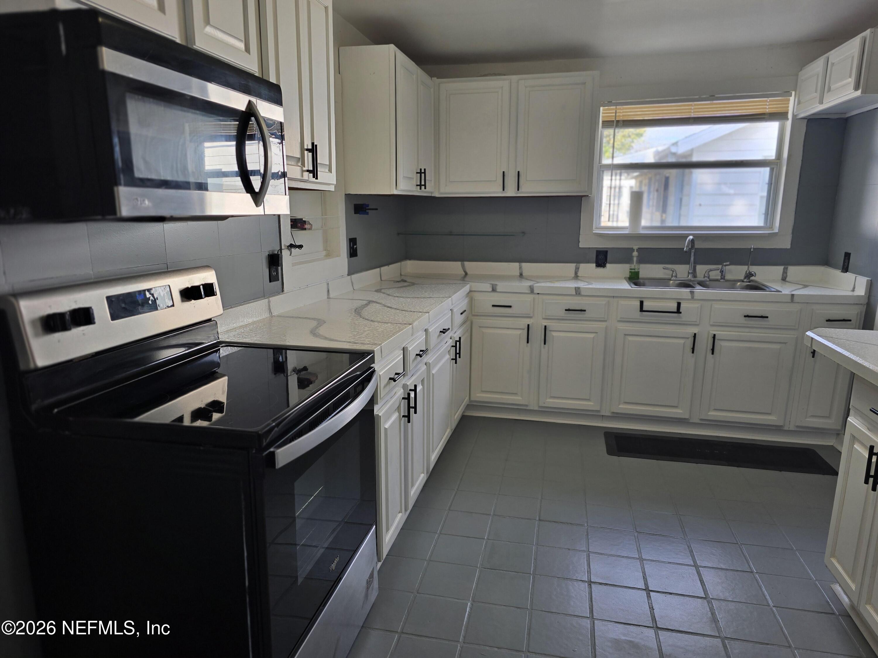 4710 Springfield Boulevard Jacksonville, FL 32206 - Photo 20 of 28 a kitchen with a sink stove and cabinets