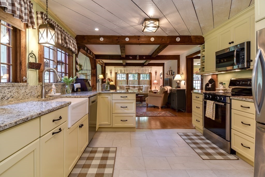 26 Woobly Road Bolton, MA 01740 - Photo 3 of 38 a large kitchen with stainless steel appliances kitchen island granite countertop a large stove top oven a sink dishwasher a dining table and chairs with wooden floor