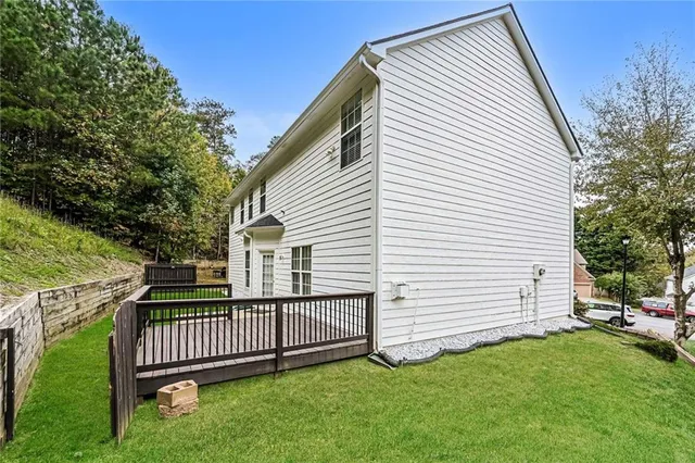 a view of a white house with a small yard and a large tree
