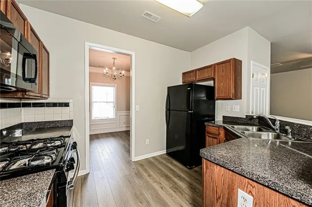 a kitchen with stainless steel appliances granite countertop a refrigerator stove and sink