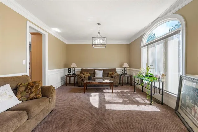 a living room with furniture a window and a chandelier