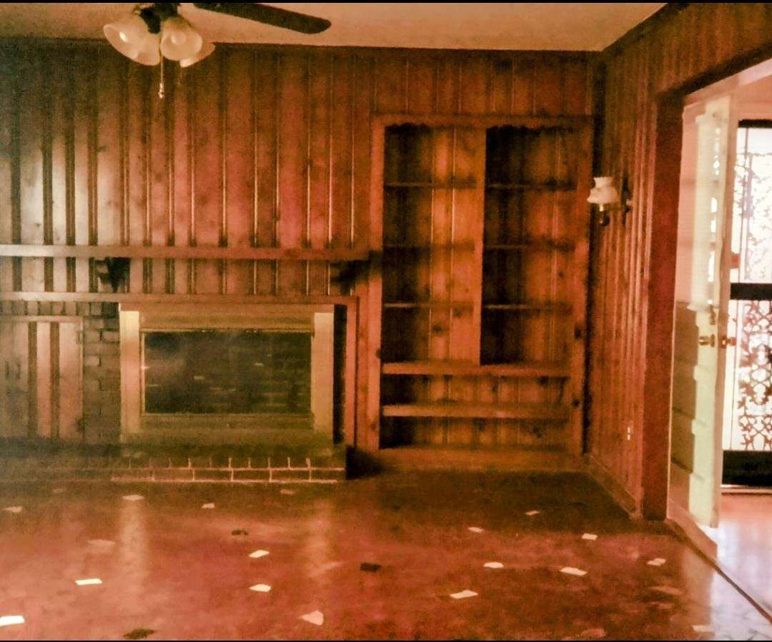 1558 Patterson Street Memphis, TN 38111 - Photo 4 of 11 Unfurnished living room with a ceiling fan and wood walls