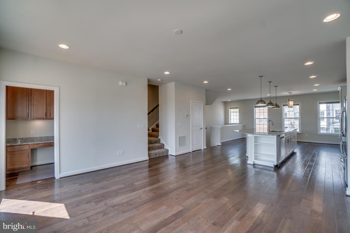 19958 Abram Terrace Ashburn, VA 20147 - Photo 11 of 41 a view of an empty room with wooden floor and a kitchen