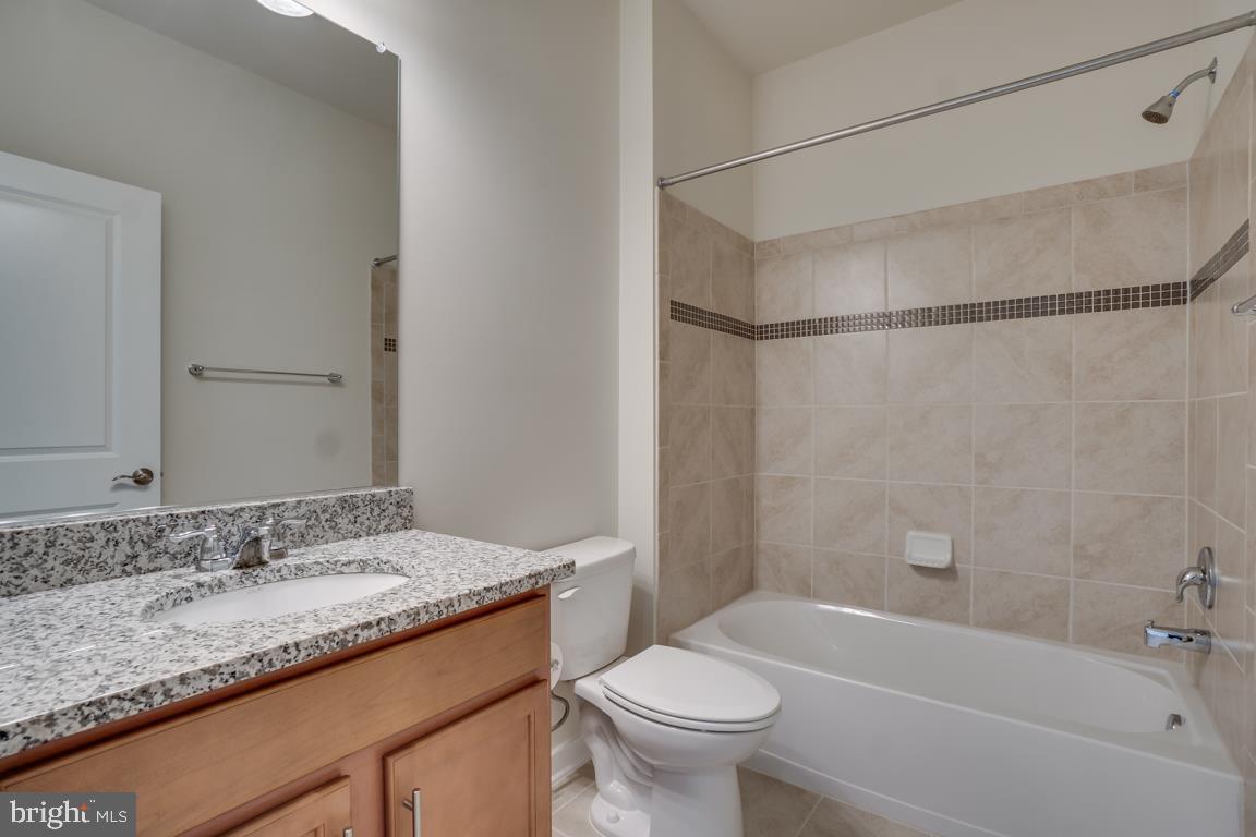 19958 Abram Terrace Ashburn, VA 20147 - Photo 31 of 41 a bathroom with a granite countertop sink mirror toilet and bathtub