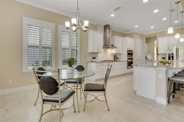 a large kitchen with stainless steel appliances kitchen island granite countertop a lot of counter space and a sink