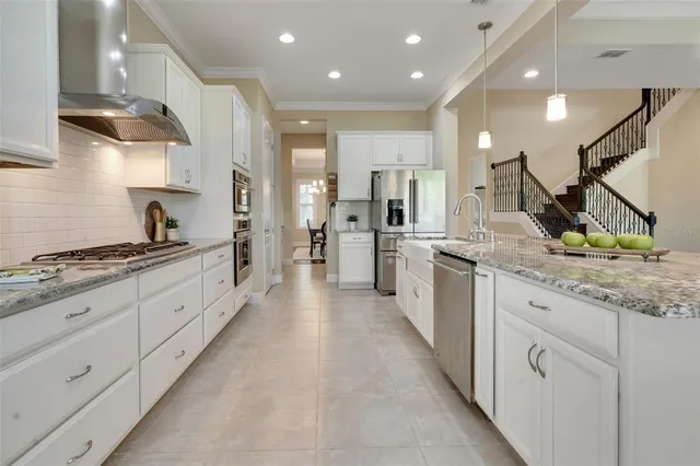 a kitchen with granite countertop a sink a stove and cabinets