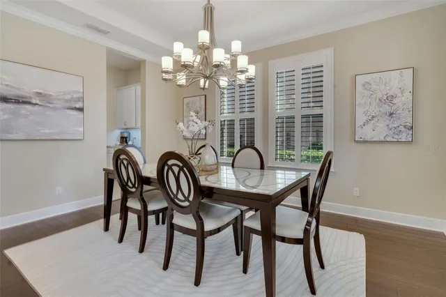 a dining room with furniture a chandelier and wooden floor
