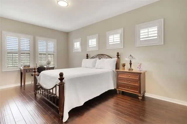a large bed sitting in a bedroom next to a window with wooden floor