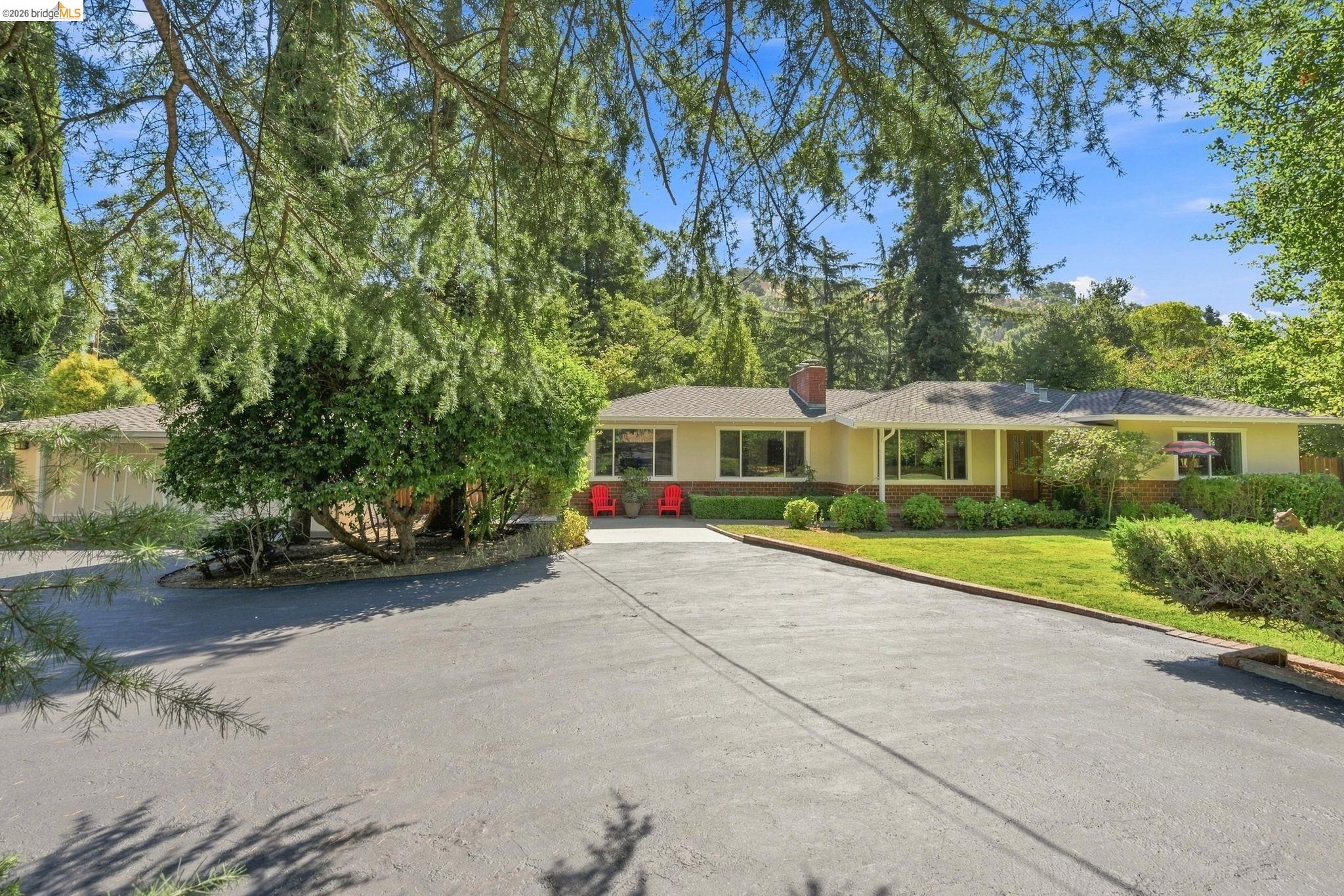 5075 Alhambra Valley Road Martinez, CA 94553 - Photo 5 of 68 Single-story residence featuring a paved driveway, mature trees, and a well-maintained lawn