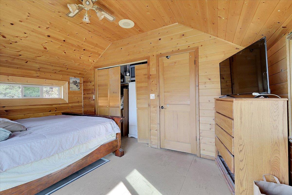 13980 Mountain House Road Penn Valley, CA 95946 - Photo 30 of 58 a bedroom with a bed flat screen tv and a window