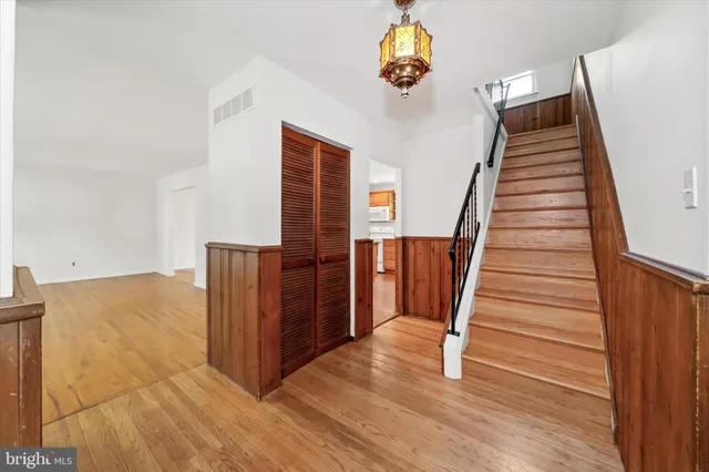 a view of a hallway with wooden floor and stairs