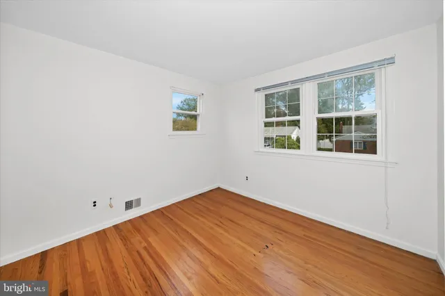 an empty room with wooden floor and closet