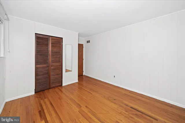 a bedroom with bed and wooden floor