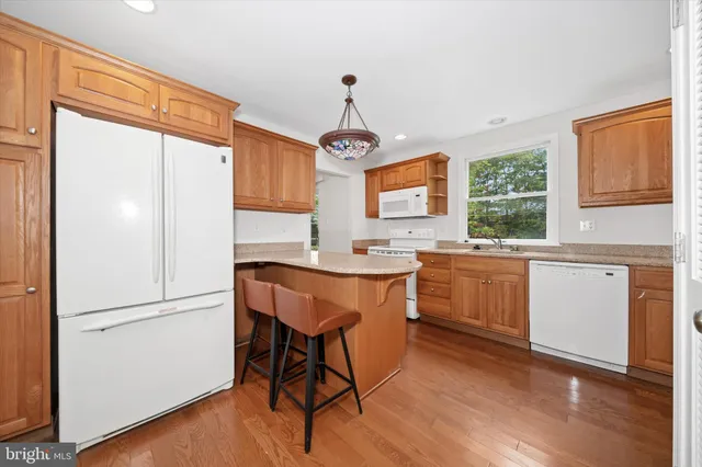 a kitchen with a refrigerator a sink cabinets and wooden floor
