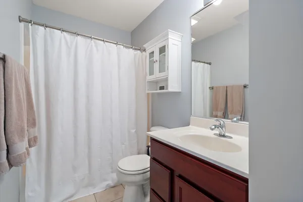 a bathroom with a sink a toilet and shower curtain