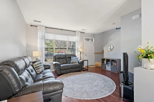 a living room with furniture and a wooden floor