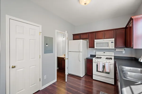 a kitchen with a refrigerator stove and wooden cabinets