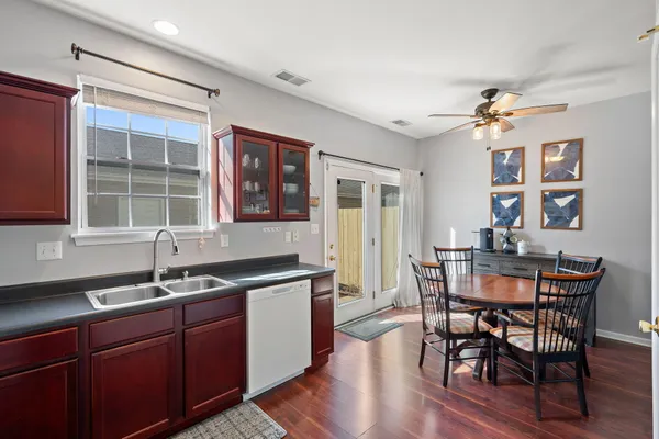a kitchen with granite countertop a sink dining table and chairs