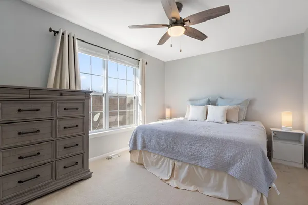 a bedroom with a large bed and a chandelier