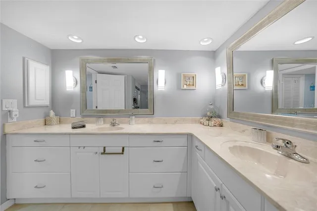 a spacious bathroom with a double vanity sink toilet and a mirror