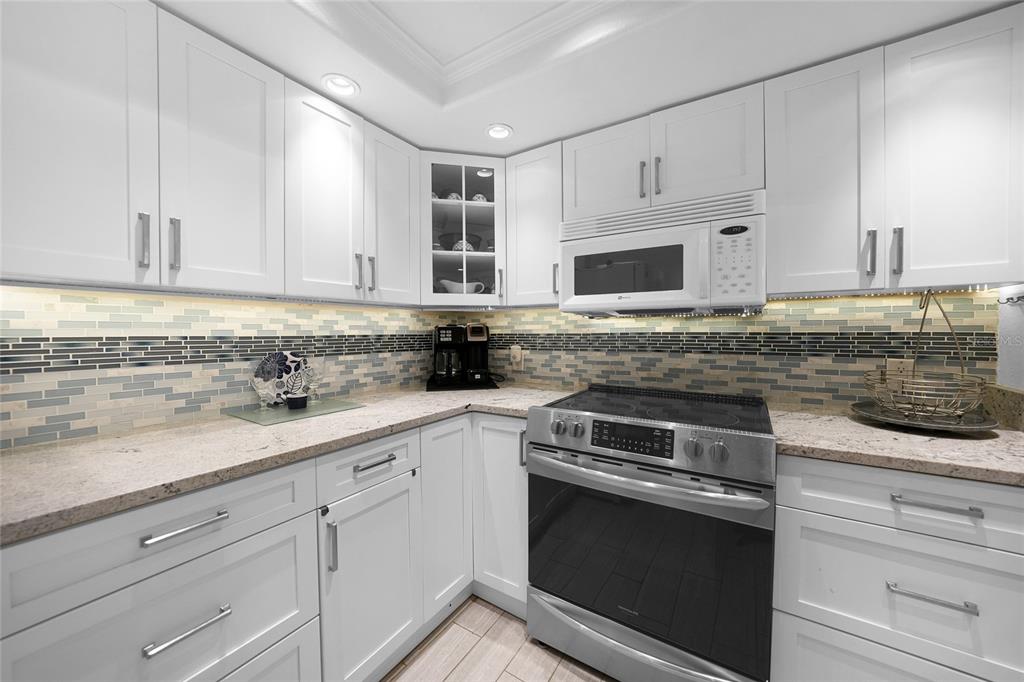 601 Shreve Street, Unit 16A Punta Gorda, FL 33950 - Photo 9 of 52 a kitchen with granite countertop white cabinets and stainless steel appliances