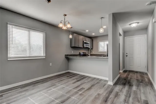 a view of kitchen with granite countertop cabinets and refrigerator