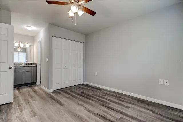 a view of a livingroom with a chandelier fan and wooden floor