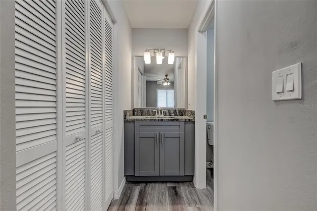 a view of a hallway with wooden floor and a kitchen