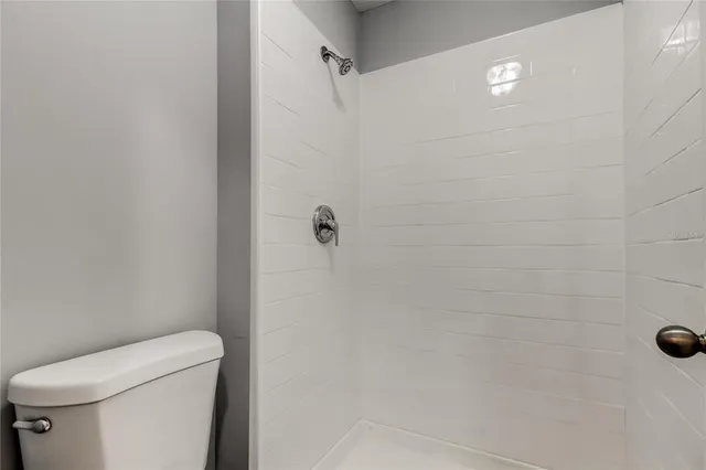 a bathroom with a toilet and a shower