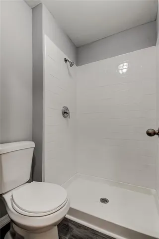 a white toilet sitting next to a bath tub