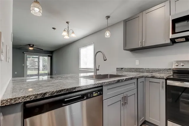 a kitchen with stainless steel appliances granite countertop a sink stove and cabinets
