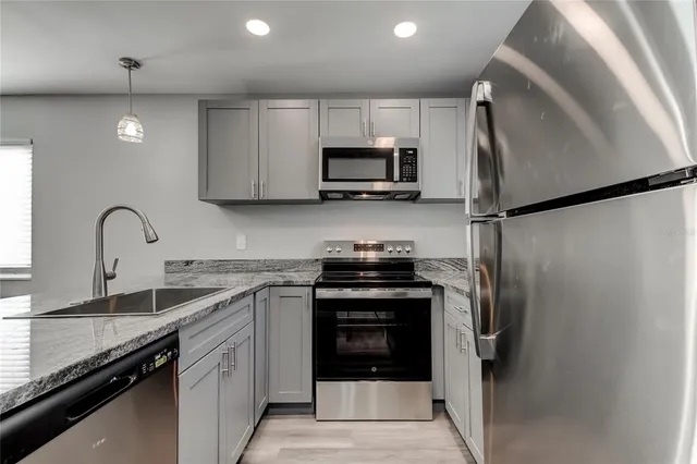 a kitchen with stainless steel appliances a refrigerator sink and white cabinets
