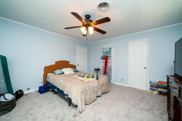 a bed room with a bed and a ceiling fan