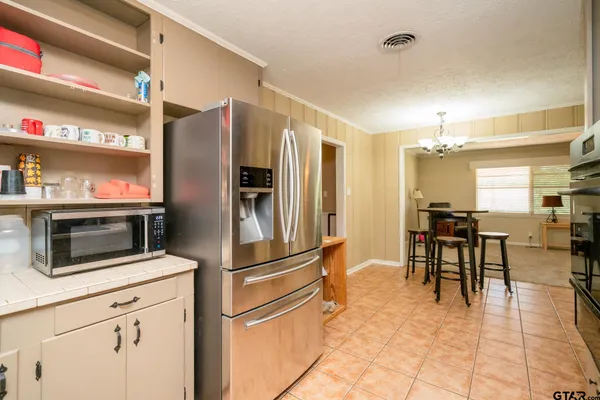 a kitchen with kitchen island a counter top space appliances and cabinets