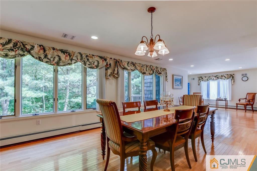 90 Union Valley Road Monroe Township, NJ 08831 - Photo 4 of 25 a dining room with furniture a chandelier and wooden floor