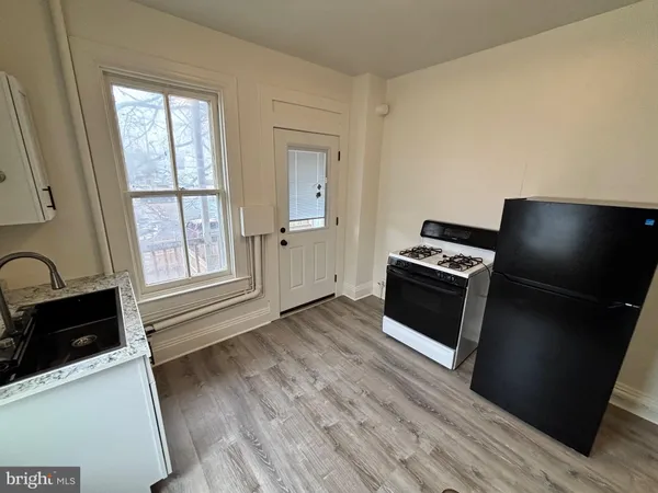 a view of kitchen with sink a microwave and cabinets