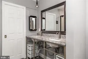a bathroom with a granite countertop sink and a mirror