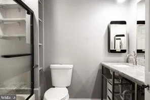 a bathroom with a toilet a sink and mirror