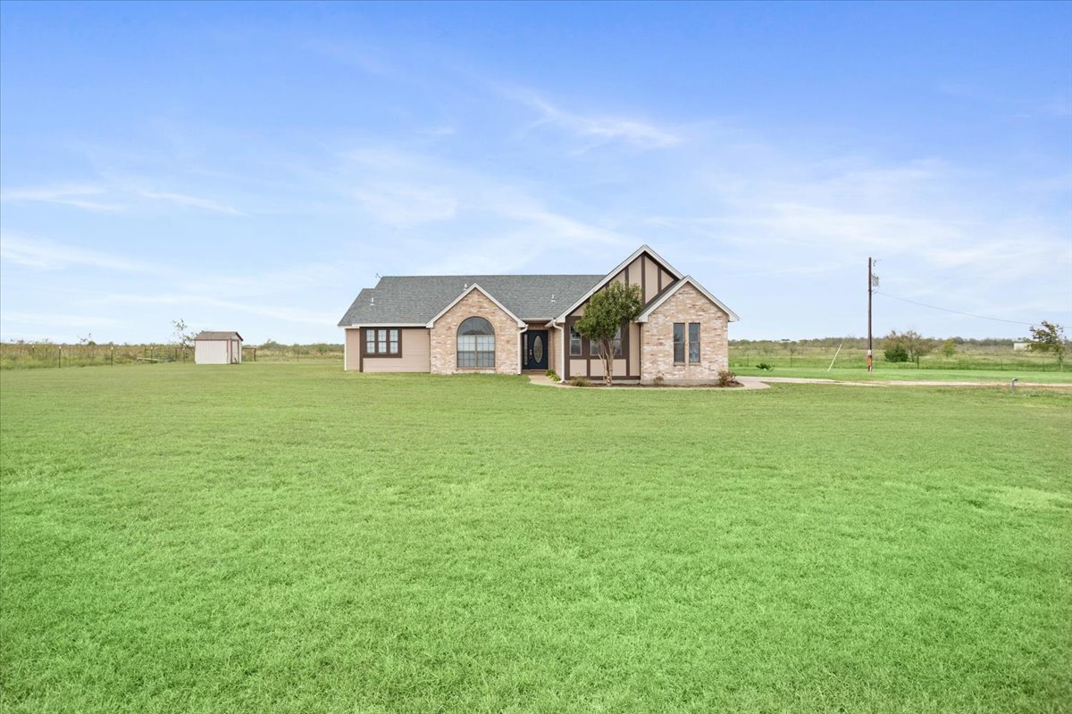 8600 Five Wells Road Rogers, TX 76569 - Photo 27 of 40 Tudor house featuring a front yard, brick siding, and roof with shingles