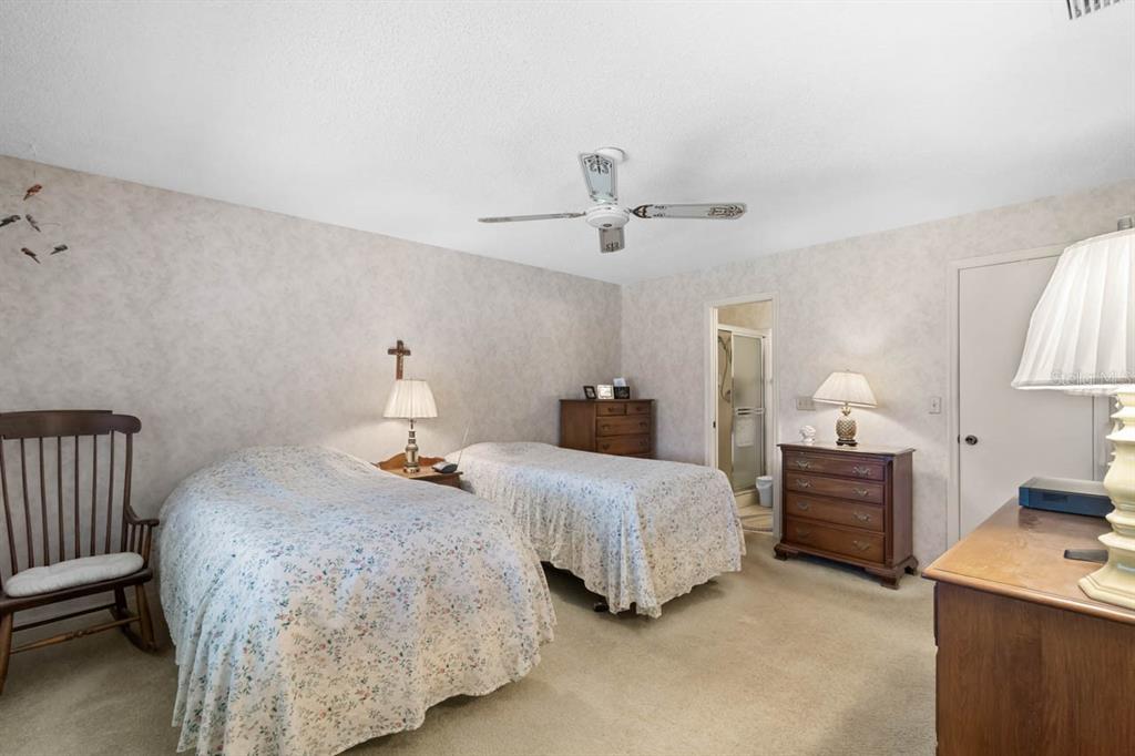 1602 Hovington Circle Sun City Center, FL 33573 - Photo 14 of 47 a bedroom with two beds and a lamp
