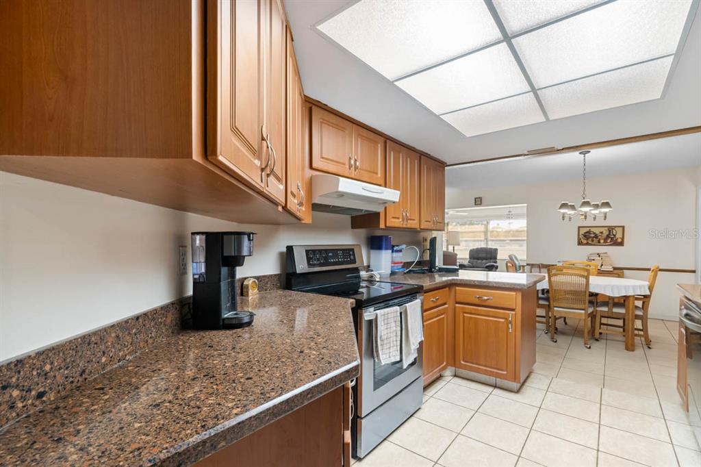 1602 Hovington Circle Sun City Center, FL 33573 - Photo 10 of 47 a kitchen with stainless steel appliances granite countertop a sink and cabinets