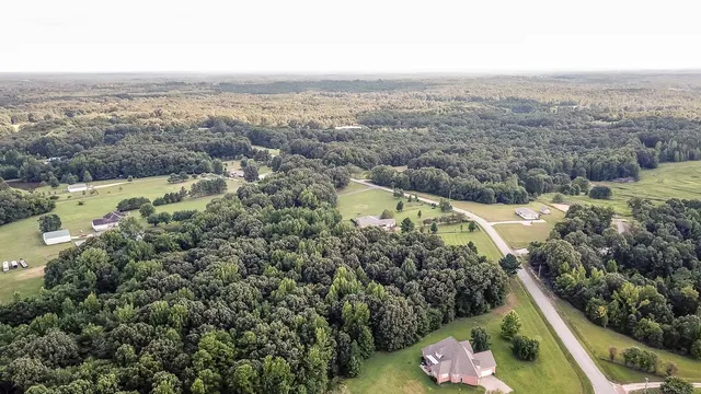 an aerial view of house with yard and mountain view in back