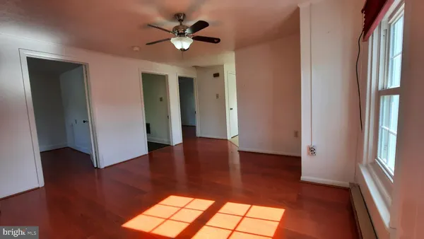 an empty room with wooden floor and window
