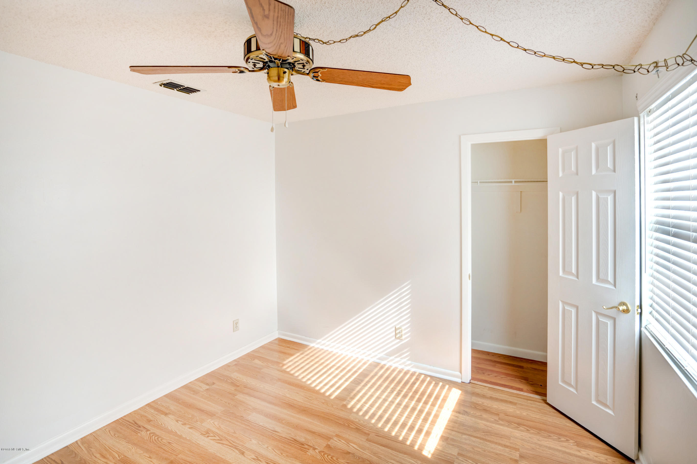 2055 Derringer Road Jacksonville, FL 32225 - Photo 13 of 25 a view of a room with wooden floor and a ceiling fan