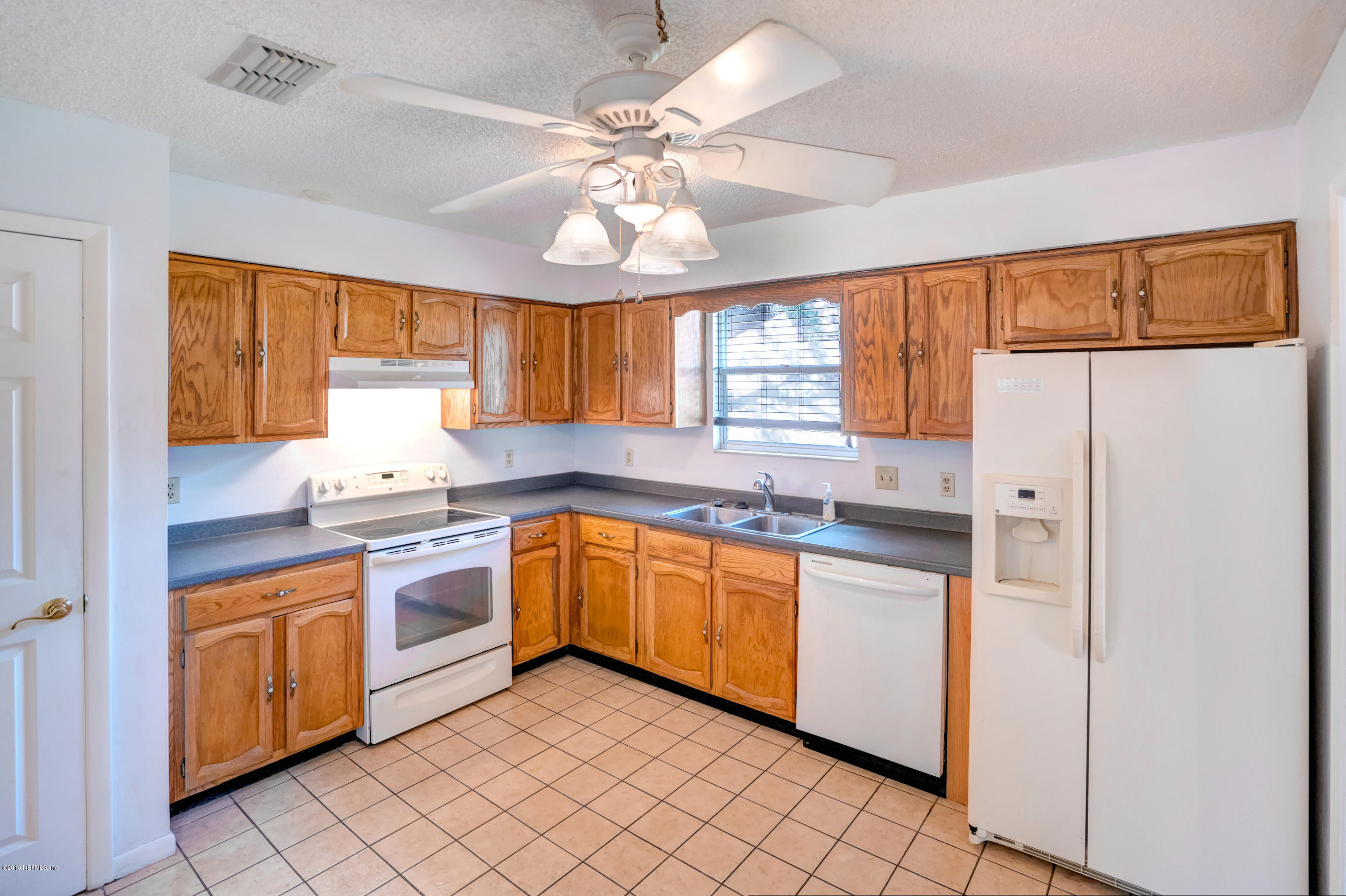 2055 Derringer Road Jacksonville, FL 32225 - Photo 8 of 25 a kitchen with granite countertop stainless steel appliances a sink cabinets and a window
