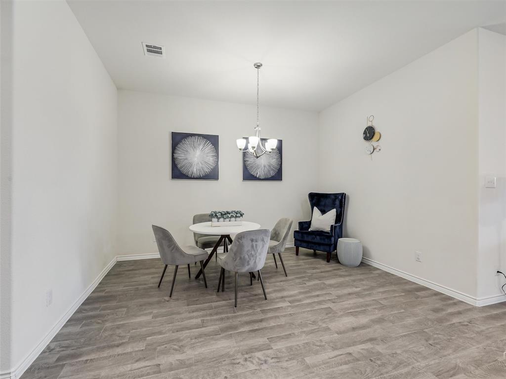 3024 Meredith Lane Forney, TX 75126 - Photo 10 of 29 Living area featuring wood-finish flooring, white walls, and a recessed ceiling vent