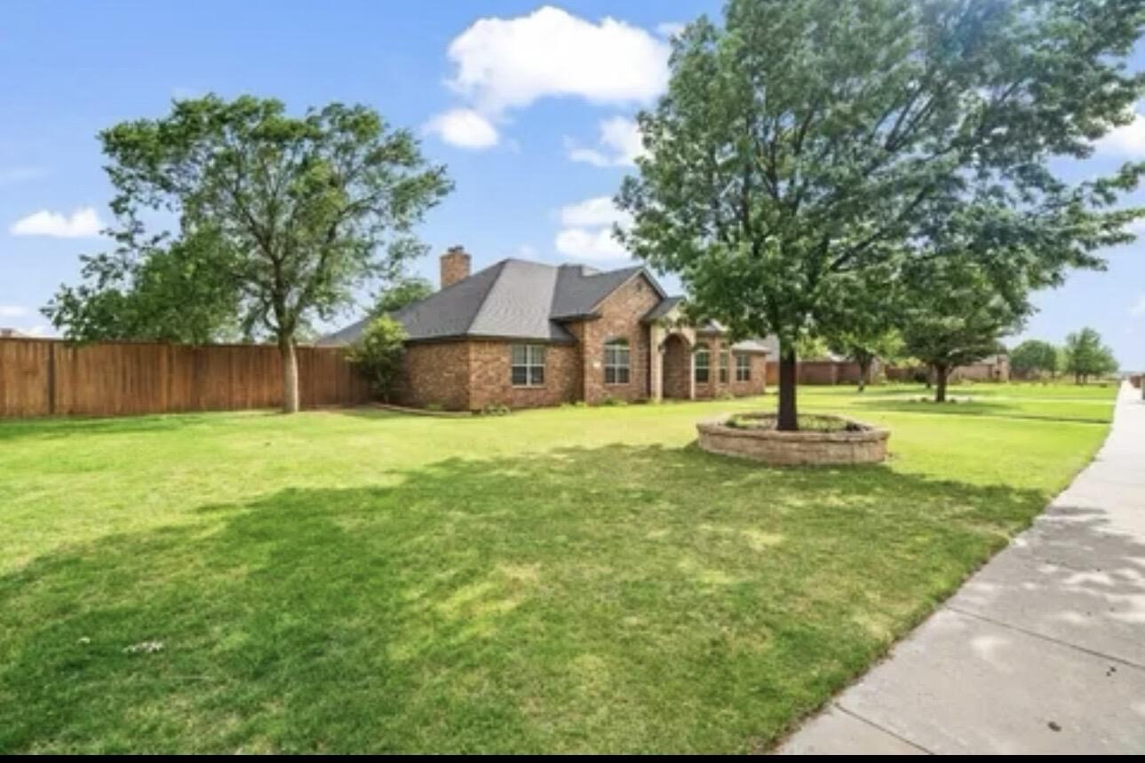 6303 112th Street Lubbock, TX 79424 - Photo 1 of 18 a front view of a house with a yard